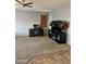 Cozy living room with a ceiling fan, desk, TV, and an entertainment center with an electric fireplace at 9108 W Kirby Ave, Tolleson, AZ 85353
