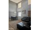 Spacious living room featuring a dark leather sofa, chandelier, and large windows for natural light at 9108 W Kirby Ave, Tolleson, AZ 85353