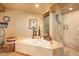 Bright bathroom featuring a soaking tub, walk-in shower, and mosaic tile surround at 9998 E Taos Dr, Scottsdale, AZ 85262