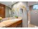 Neutral bathroom with a tile countertop vanity, large mirror, and walk-in shower at 9998 E Taos Dr, Scottsdale, AZ 85262