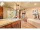 Bright bathroom with a large mirror, soaking tub, walk-in shower, and marble countertops at 9998 E Taos Dr, Scottsdale, AZ 85262