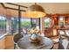 A cozy breakfast nook area with a round wooden table with chairs overlooking the outdoor patio at 9998 E Taos Dr, Scottsdale, AZ 85262