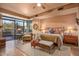 A sun-filled main bedroom showcasing wood floors, patio access, and comfortable seating area at 9998 E Taos Dr, Scottsdale, AZ 85262