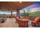 Charming covered patio featuring an outdoor kitchen, comfortable seating, and a serene desert landscape backdrop at 9998 E Taos Dr, Scottsdale, AZ 85262