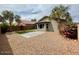 Spacious backyard with desert landscaping, an artificial lawn, and mature palm trees at 3229 W Five Mile Peak Dr, San Tan Valley, AZ 85144