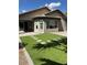 Inviting backyard with lush artificial grass, a stone patio, and mature trees at 3229 W Five Mile Peak Dr, San Tan Valley, AZ 85144