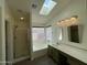 Bright bathroom featuring a skylight, shower, and vanity with plenty of natural light at 3229 W Five Mile Peak Dr, San Tan Valley, AZ 85144