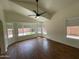 Spacious bedroom with wood-look tile floors, vaulted ceiling, and large windows overlooking the backyard at 3229 W Five Mile Peak Dr, San Tan Valley, AZ 85144