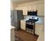 Functional kitchen with stainless steel appliances, white cabinets, wood-look floors, and ample counter space at 3229 W Five Mile Peak Dr, San Tan Valley, AZ 85144