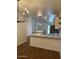 Contemporary kitchen with white cabinets, a center island, and wood-look flooring open to living spaces at 3229 W Five Mile Peak Dr, San Tan Valley, AZ 85144
