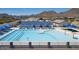 Community pool with lap lanes, lounge chairs under blue umbrellas, and mountain views at 3229 W Five Mile Peak Dr, San Tan Valley, AZ 85144