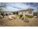 Landscaped backyard with rocks, artificial turf, a covered patio, and a view of the pool at 34047 N 10Th St, Phoenix, AZ 85085