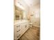 Bright bathroom featuring white cabinets, modern fixtures, and a large mirror, complemented by wood-look tile flooring at 34047 N 10Th St, Phoenix, AZ 85085