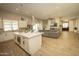 View of the open concept kitchen, living and dining area with an island, fireplace, and light color scheme at 34047 N 10Th St, Phoenix, AZ 85085