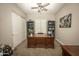 A home office with a dark wood desk, built-in shelving, a ceiling fan, and a sliding door at 34047 N 10Th St, Phoenix, AZ 85085