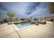 Backyard pool and spa with desert landscaping, poolside seating and a partly cloudy blue sky at 34047 N 10Th St, Phoenix, AZ 85085
