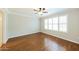 Light-filled bedroom featuring hardwood floors, neutral walls, trim, and a ceiling fan at 3774 W Wood Dr, Phoenix, AZ 85029
