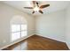 Bedroom with hard wood floors, arched window, ceiling fan, and neutral paint at 3774 W Wood Dr, Phoenix, AZ 85029