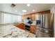 Well-lit kitchen with stainless steel appliances, granite countertops, and wooden cabinets at 3774 W Wood Dr, Phoenix, AZ 85029