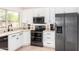 Modern kitchen showcasing stainless steel appliances, white cabinetry, and a large window at 4106 E Lavender Ln, Phoenix, AZ 85044
