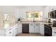 Bright kitchen featuring stainless steel appliances, white cabinets, and direct access to the backyard patio at 4106 E Lavender Ln, Phoenix, AZ 85044