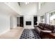 Bright living room with high ceilings, a fireplace, tiled floors, and a comfortable leather sofa at 4106 E Lavender Ln, Phoenix, AZ 85044