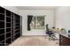 Bright office space featuring built-in shelving, a comfortable workspace, and a view of the landscaped yard at 4106 E Lavender Ln, Phoenix, AZ 85044