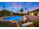 Inviting backyard with a sparkling pool, lush landscaping, a cozy fire pit, and comfortable seating area at 5001 E Redfield Rd, Scottsdale, AZ 85254