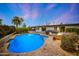 Lush backyard features a sparkling pool, a tanning deck, lounge chairs, and a lounge area around a fire pit at 5001 E Redfield Rd, Scottsdale, AZ 85254