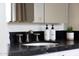 Close-up of a bathroom sink with black countertop and decorative lotion and soap bottles at 5001 E Redfield Rd, Scottsdale, AZ 85254