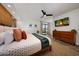 Comfortable main bedroom with fan, TV, dresser, and sliding door access to outside at 5001 E Redfield Rd, Scottsdale, AZ 85254