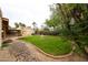 Backyard featuring a manicured lawn with a charming fountain, bordered by mature trees, providing a serene outdoor space at 5120 E Janice Way, Scottsdale, AZ 85254