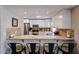 Modern kitchen showcasing stainless steel appliances, granite countertops, and a breakfast bar with seating for four at 5120 E Janice Way, Scottsdale, AZ 85254