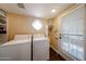 Bright laundry room features a window, storage shelves, and washer and dryer at 5120 E Janice Way, Scottsdale, AZ 85254