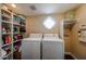 Bright laundry room with a window, storage shelves, and appliances at 5120 E Janice Way, Scottsdale, AZ 85254