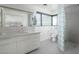 Modern bathroom featuring a large mirror, white cabinets, tiled floors, and a glass block shower wall at 5412 E Rockridge Rd, Phoenix, AZ 85018