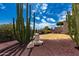 Backyard featuring mature desert landscaping, gravel and stone accents, and lawn at 6043 W Robin Ln, Glendale, AZ 85310