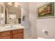 Cozy bathroom with classic vanity, large mirror, and framed artwork at 6043 W Robin Ln, Glendale, AZ 85310