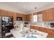 Functional kitchen with wood cabinetry, a central island, and standard appliances at 6043 W Robin Ln, Glendale, AZ 85310