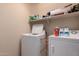 Laundry room featuring white washer and dryer and overhead shelving at 6043 W Robin Ln, Glendale, AZ 85310