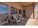 Covered patio with tiled floor, white plastic chairs and view of the desert landscape at 6043 W Robin Ln, Glendale, AZ 85310