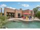 Spacious backyard showcasing a waterfall pool and covered patio at 11366 E White Feather Ln, Scottsdale, AZ 85262