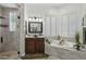 Bright bathroom showcasing a soaking tub, walk-in shower, wood floors, and granite counters at 11366 E White Feather Ln, Scottsdale, AZ 85262