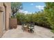 Outdoor dining on the patio with travertine flooring, privacy wall, and desert landscaping at 11366 E White Feather Ln, Scottsdale, AZ 85262
