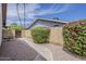Private backyard courtyard featuring a curved walkway, mature landscaping, and a charming seating area at 14221 N 45Th St, Phoenix, AZ 85032