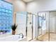 Serene bathroom with a glass-enclosed shower, soaking tub, and bright natural light from a glass block window at 14253 N Honeysuckle N Dr, Fountain Hills, AZ 85268