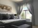 Stylish bedroom featuring a king-size bed, gray walls, accent furniture, and soft natural light through a window at 14253 N Honeysuckle N Dr, Fountain Hills, AZ 85268