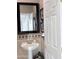 Elegant half-bathroom featuring a pedestal sink, decorative mirror, and charming wall decor at 14253 N Honeysuckle N Dr, Fountain Hills, AZ 85268