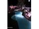 Night shot of a beautifully illuminated pool featuring a rock waterfall and hot tub at 14253 N Honeysuckle N Dr, Fountain Hills, AZ 85268