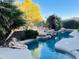 Beautiful swimming pool featuring a unique rock waterfall, lush landscaping, and serene ambiance at 14253 N Honeysuckle N Dr, Fountain Hills, AZ 85268